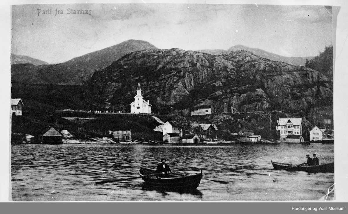 Stamnes sett frå sjøen, med to robåtar på fjorden