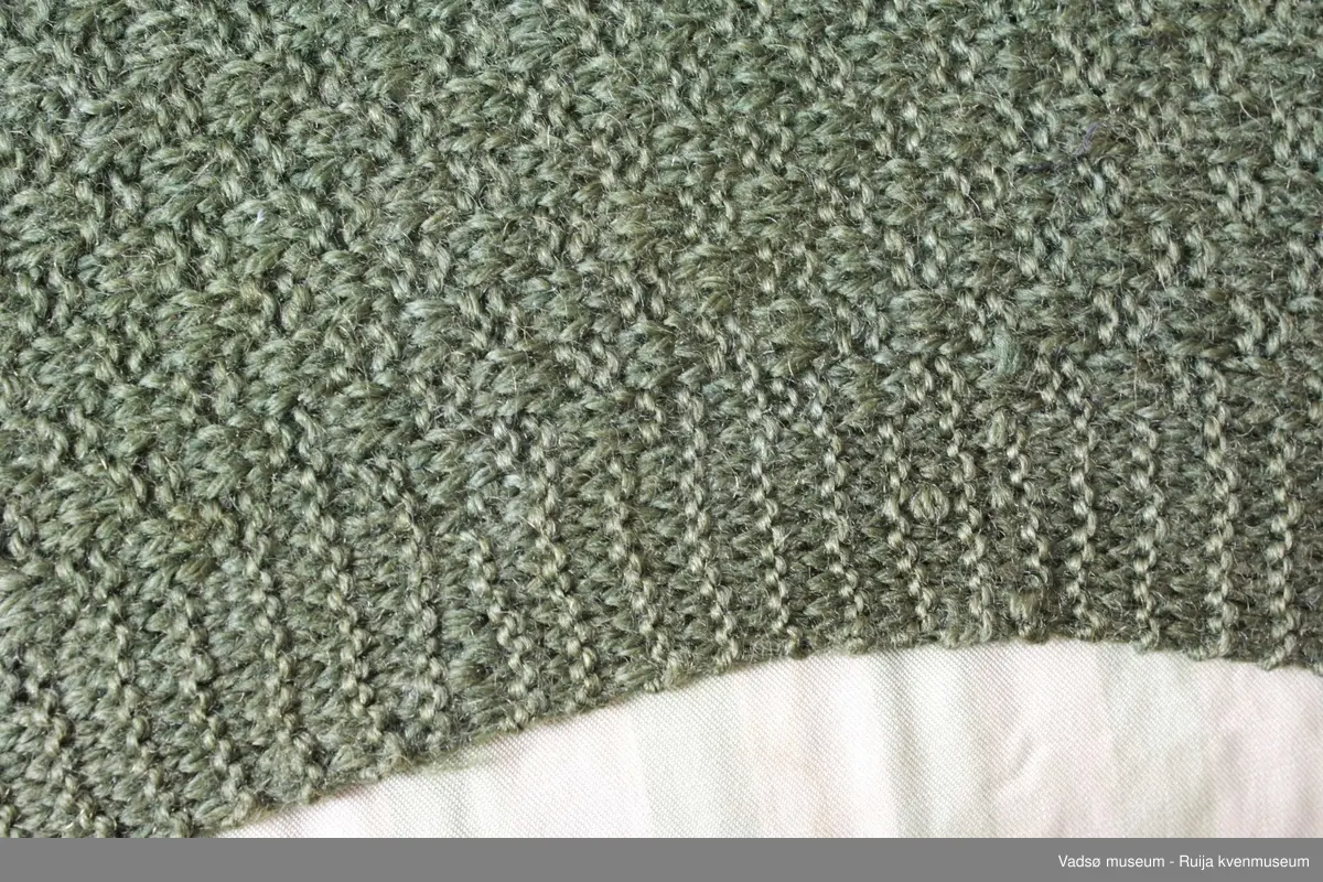 1 stk pute. Tidl. reg. brodert korssting på tysk sekk.Fra ca. 1942-43
Blomstermotiv i midten, striper diagonalt i hjørnene. Strikket grønn bakside.