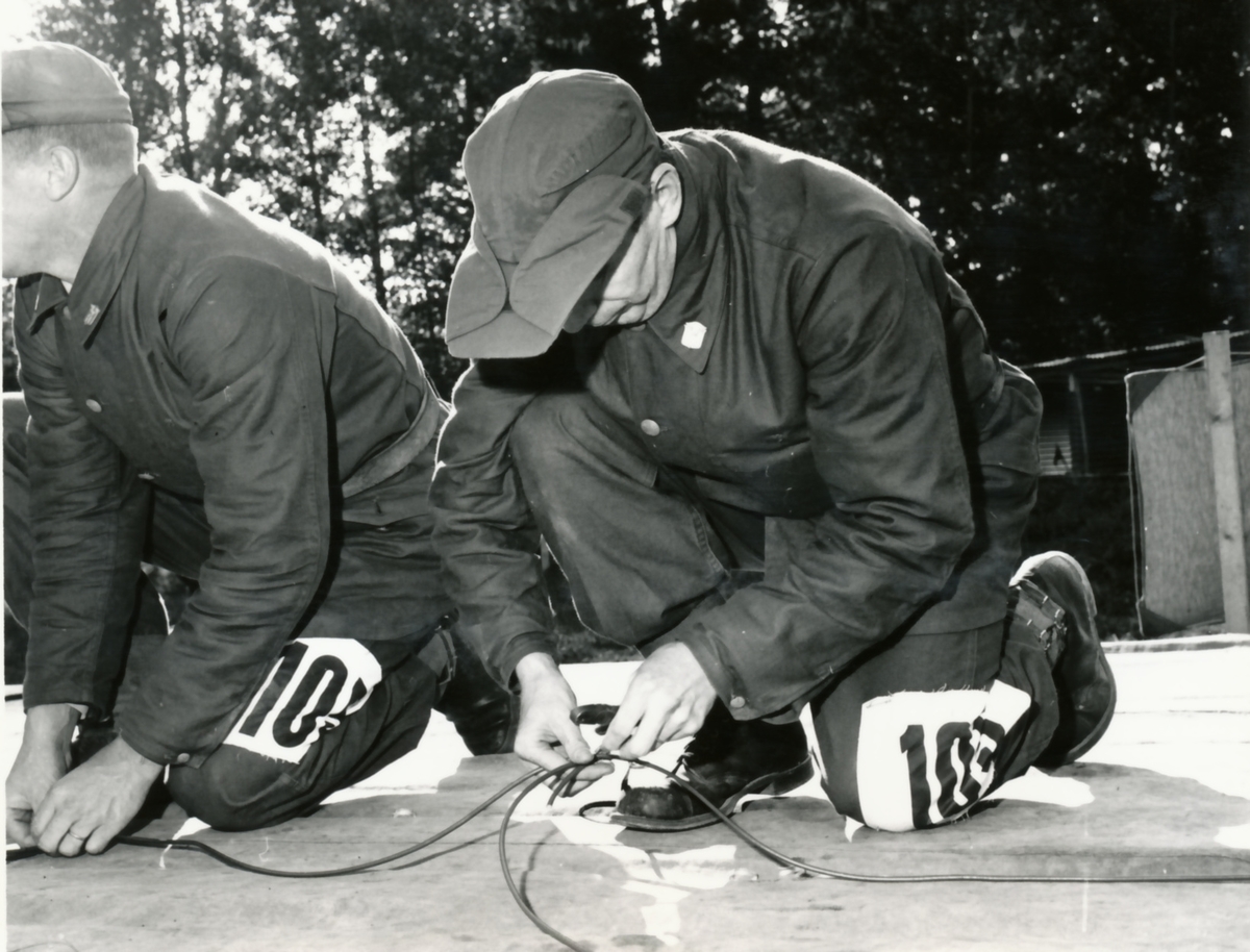 Rikshemvärnstävlingen 1967, sid 14 och 15

Min- och sprängtjänst.
Gruppen förbereder sprängning av en träbro med stridsvagnsminor. Minorna tänds med Sprängdeg och Pentylstubin.

Bild 1. Lag 105, TV Karlstad utför en korrekt 90-graders skarv på ringledning av Pentylstubin.

Bild 2. Lag 13, Hallabro, Fo 15. Gunnar Augustson och Per Pettersson.

Bild 3 och 4. Från samma stn.