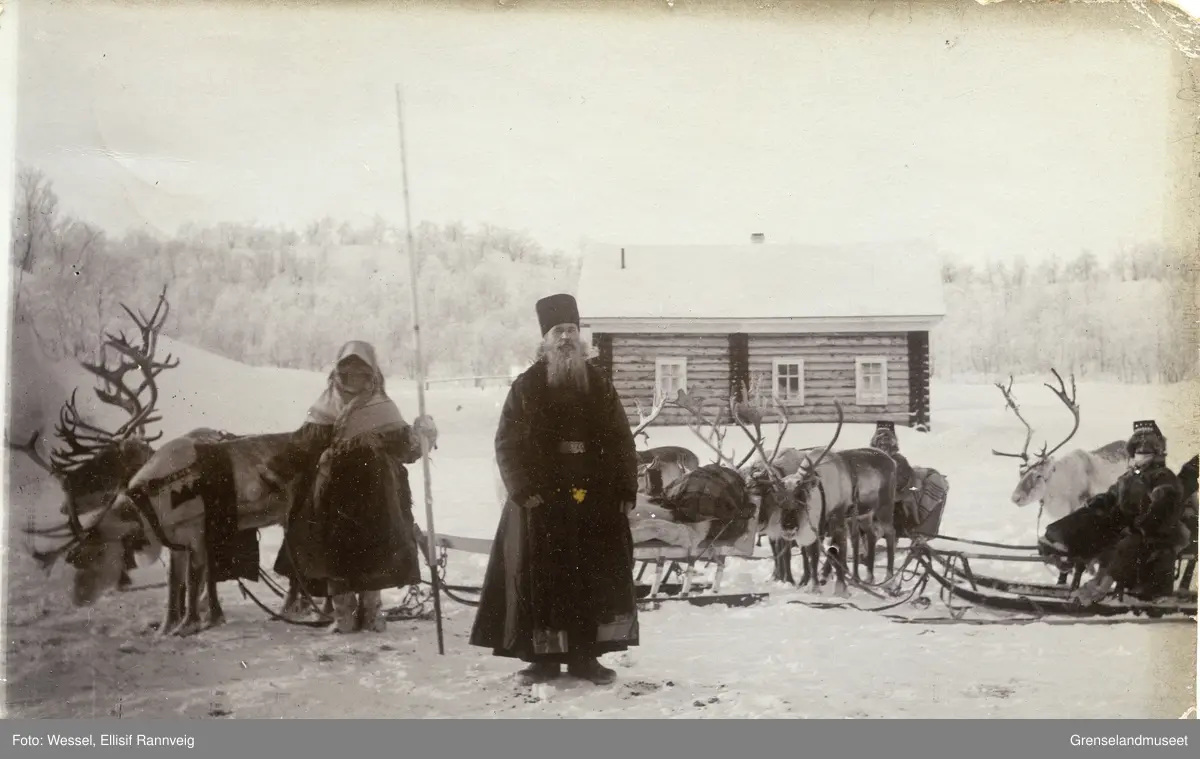 En reinraid bestående av tre tundrasleder i en russisk skolteby. En kvinne står og holder de fremste reinene og to menn sitter i de to andre sledene. Munken i midten heter muligens Josef.