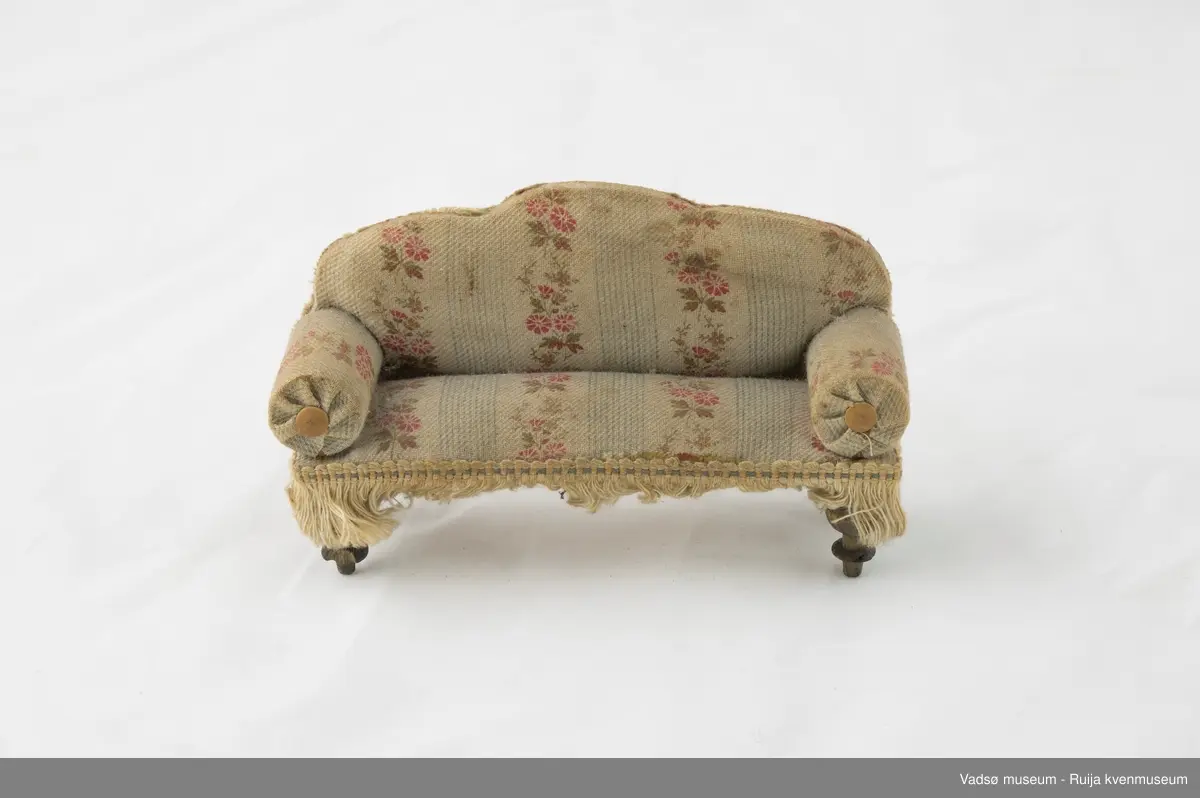 Sofa i miniatyrstørrelse. Kledd i sandfarget tekstil. Dreide bein.