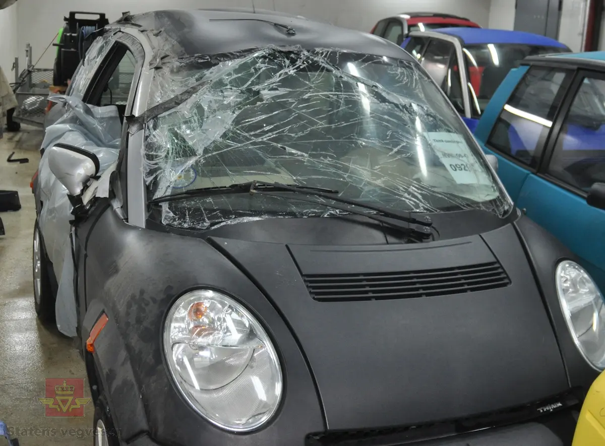 Sort sidekollidert elektrisk drevet personbil Pivco City/306/Piv5. Bilen er kollidert fra høyre side. 

Bilen har et karosseri av termoplast, (polyetylen) og et tak av ABS plast. Underramme av stål og overramme av aluminium. Kollisjonsbjelker i dørene. Deformasjonssoner. Farget glass, sort og grått interiør. Den har en motor på 34 kW maks effekt, og et zebrabatteri som ved en temperatur over 200 grader inneholder 25 kWh energi.