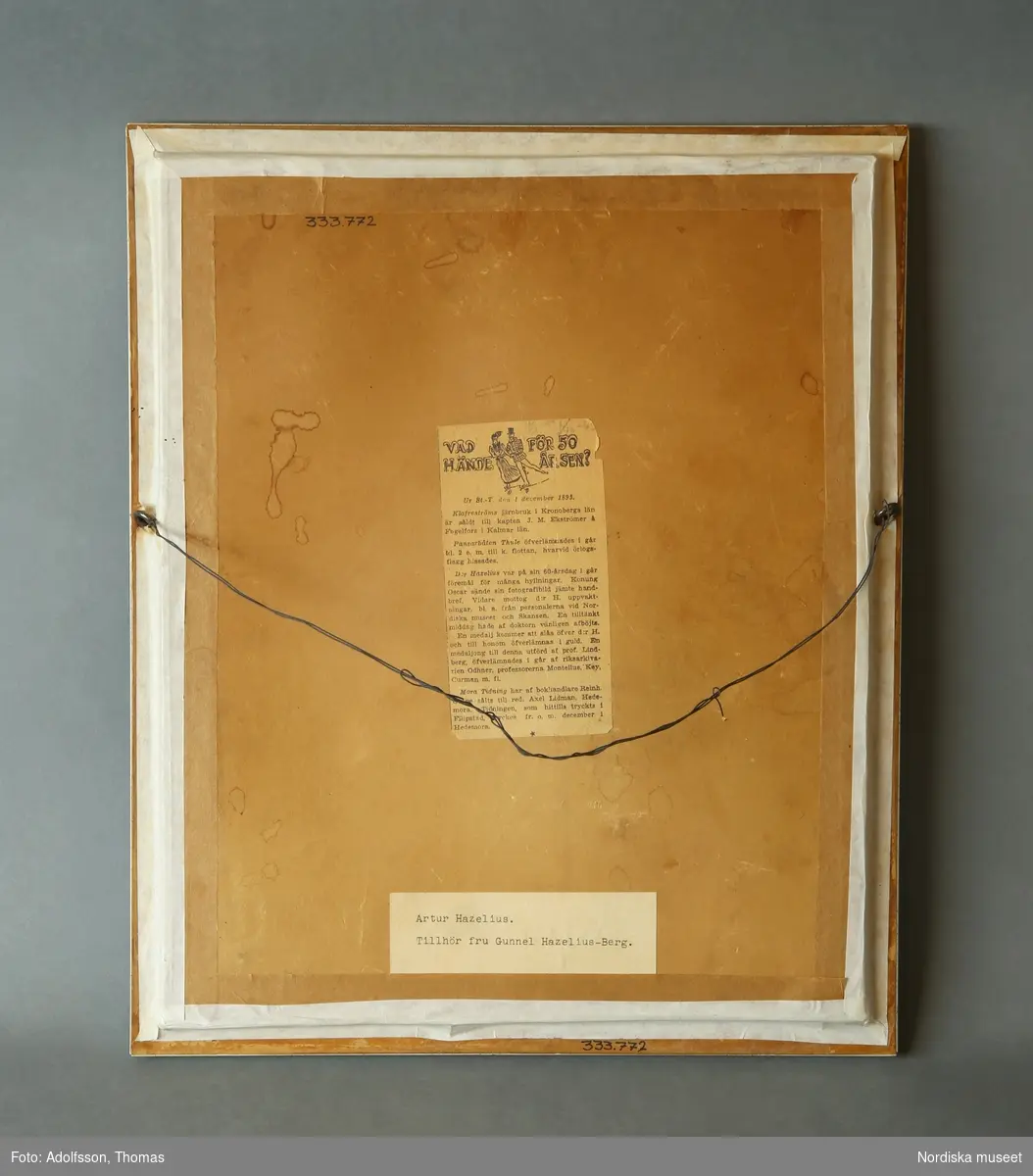 Inramat porträtt i profil av Artur Hazelius. Utförd i rödfärgad gips, infäst i mot bakgrund.