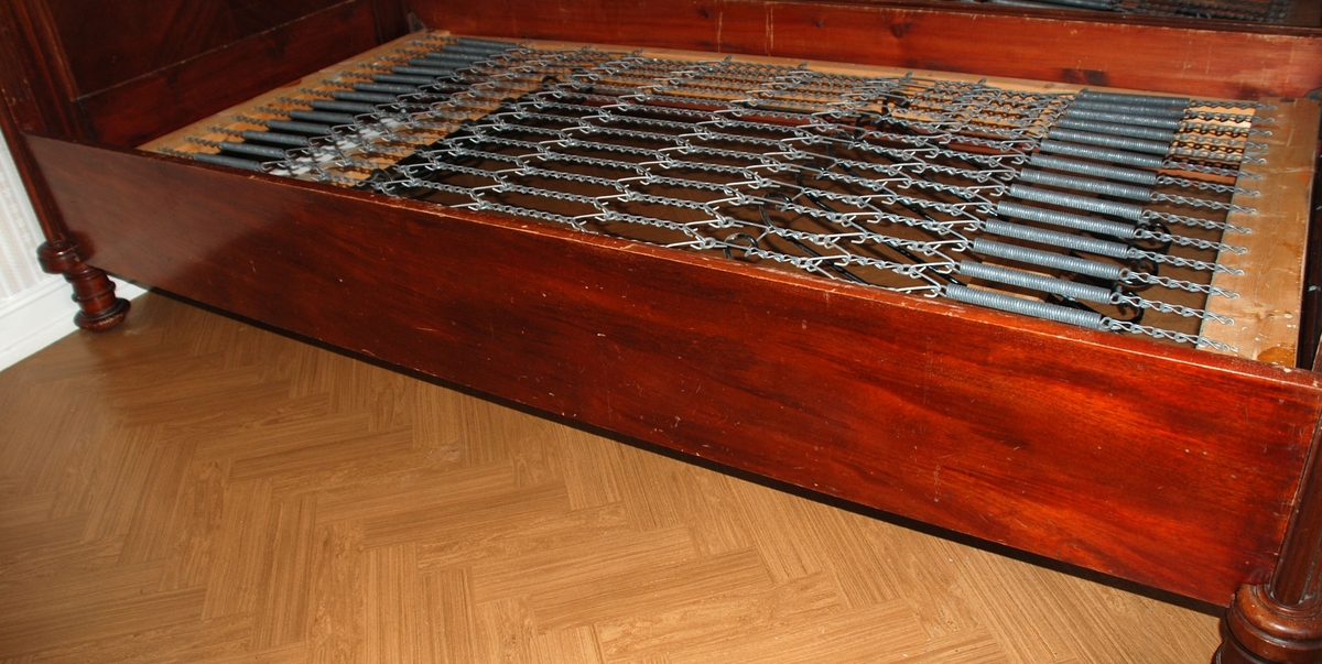 Dobbelseng som består av to enkeltsenger som står inntil hverandre. Mørkbeiset brun seng i heltre og finèr.