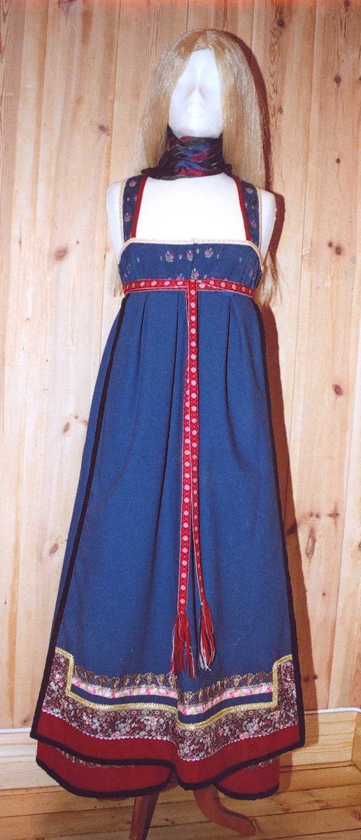 Uppluten sydd av blomstrete tøy og har perler bak. Kanta med ull og bomull. Bringekluten kan brukast på begge sider, raud på den eine, blå og lys gul på den andre. Forkleet kan og brukast på begge sider, blått på eine sida, lyst på den andre. Beltet skal brettast ned, slik at det framleis viser rettsida ut, når forkleet blir bruka på den blå sida. Forkleet er kanta med blått fløyelsband. Forkle, stakk og bringeklut er pynta med agramaner i gull og sylv. Band til pynt, ingen broderi. Drakta kan brukast i ulike samanhengar. Høgtidskledd med raud bringeklut. Med kvitt forkle er det eit endå meir høgtidsprega. Dersom ein i tillegg har la og belteklutar så er det brurestakk. Brukar ein lærbelte, er det meir kvardagplagg. Drakta kan varierast med forskjellige skjorter, sylv, plagg, og kan passe til mange typar bruk. Med den lyse sida av bringekluten fram er det meir kjøkkenfargr og meir sommarleg. Utan bringeklut kan ein bruke silkeplagg i bringa. Med  mindre pynt vert han tøffare, ein kan nesten bruke T-skjorte i staden for bunadsskjorte. 