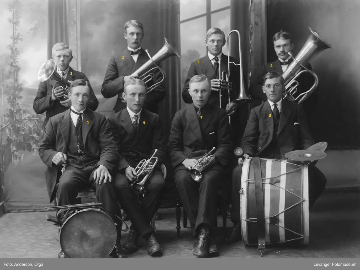 Gruppebilde av musikklag/orkester med blåsere og trommer