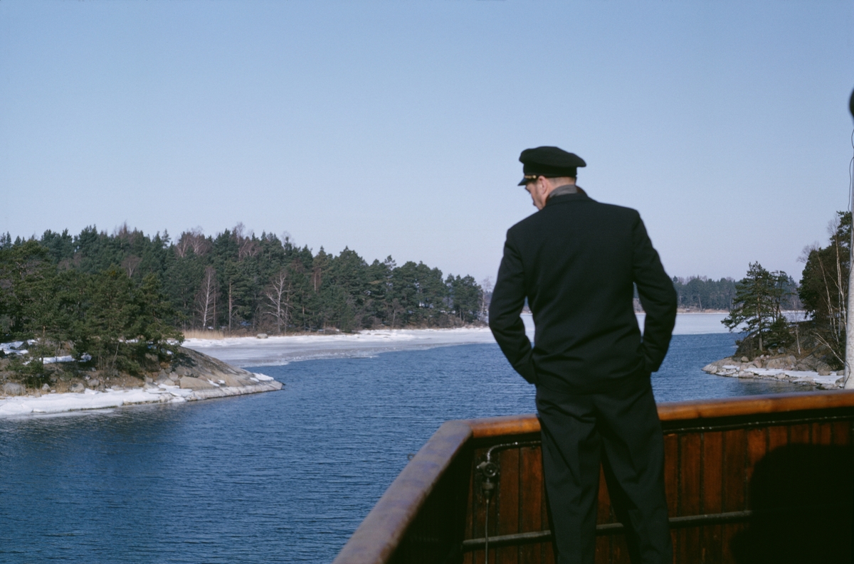 Besättningsmedlem tittar ut över relingen norr om Ytterö.