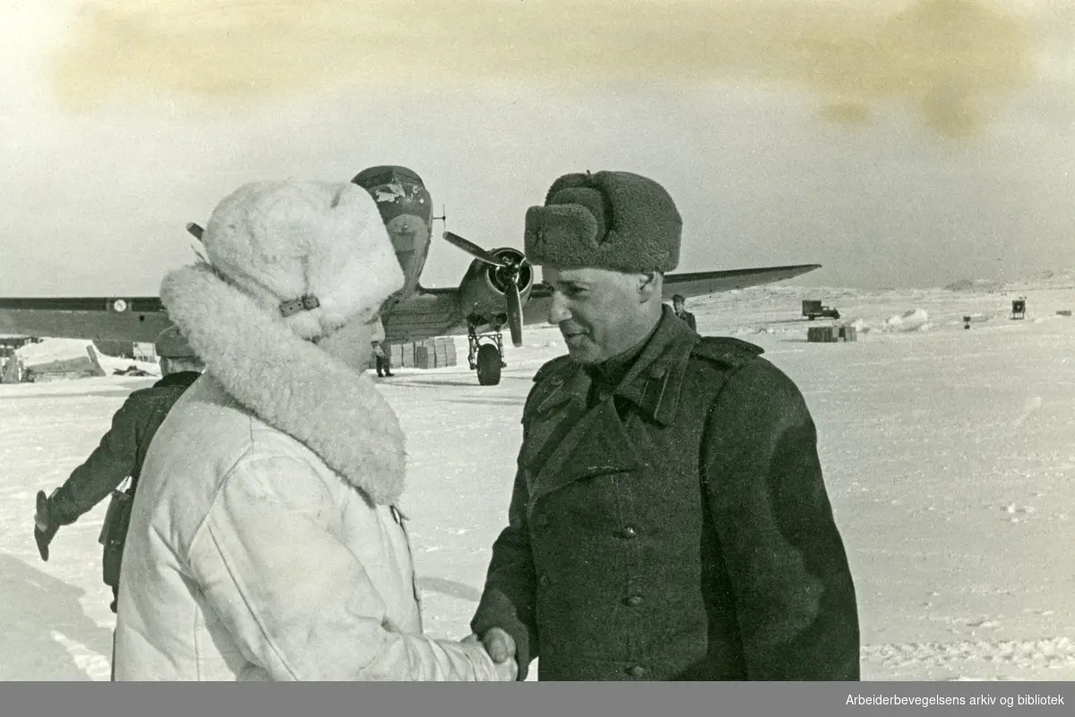 Amerikanske Dakota-fly er hovedforbindelsen mellom Sverige og Nord-Norge. På bildet hilser en russisk offiser statsråd Anders Frihagen (Til venstre) velkommen på en flyplass (Høybuktmoen) i Nord-Norge.