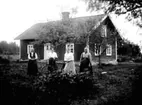 FYRA KVINNOR I TRÄDGÅRDEN FRAMFÖR ETT BOSTADSHUS, DEN ENA HÅLLER I EN CYKEL.

Fotot taget i sept.1917.
