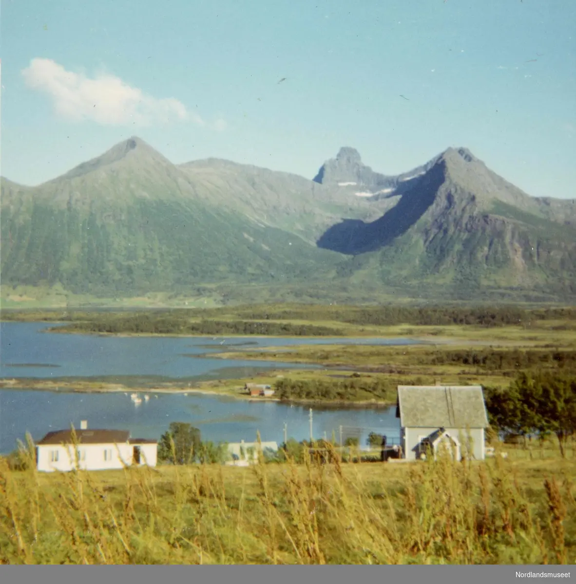 Landskap med hus i forgrunnen. Bildet er tatt fra Leirvik mot Stensland, med fjellet Hatten ca. midt på.