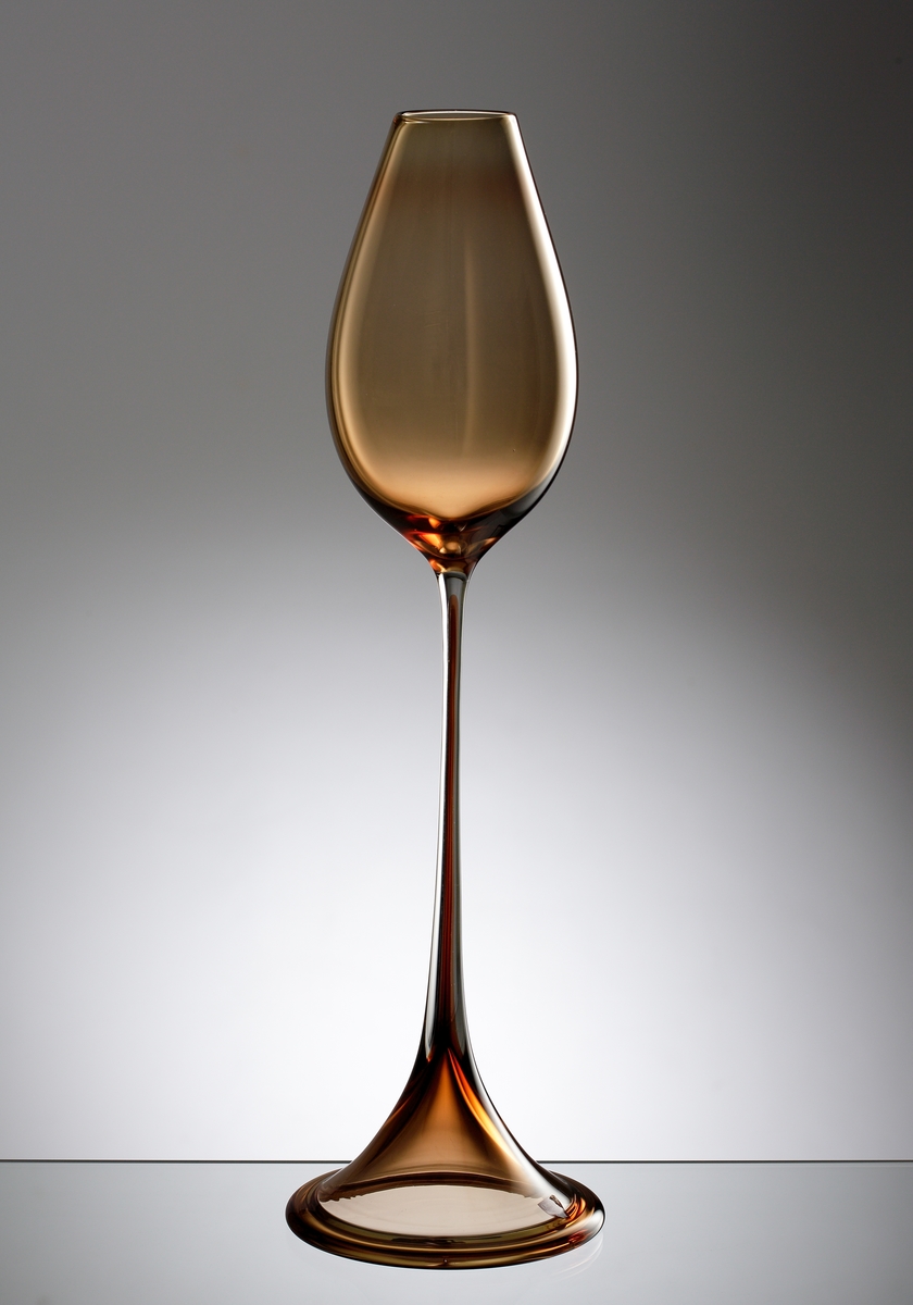 "Tulpanvas" av Nils Landberg i bernstensfärgat underfång. Högt ben och generös kupa som markant sluter sig mot mynningen.