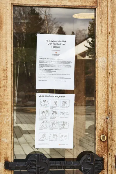 Koronaskilt på kirkedør på Østerås under koronanedstengningen