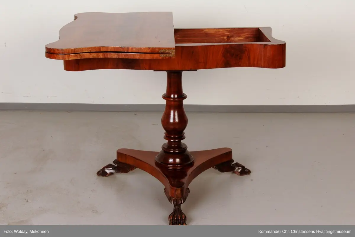 Bord hvor platen holdes oppe av dreid sokkel som hviler på fotplate med 3 utskårne bein. Bordplaten er hengslet på midten
Platen har avrundede hjørner