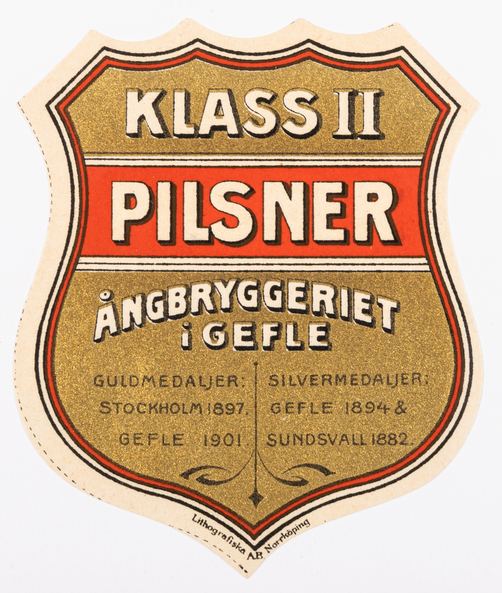 Etiketter. Sköldformade, Guld, rött, vitt, svart. "KLASS II PILSNER ÅNGBRYGGERIET I GEFLE..." Tryckt hos "Södra Norrlands Lito. Anst Gefle."