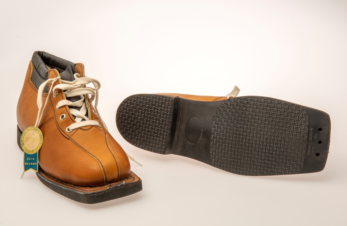 Skisko/Beksøm, lys brune med sort ankelstøtte. Sort gummisåle. Hvite skolisser. Hull til rottefellebindinger. Størrelse 41.