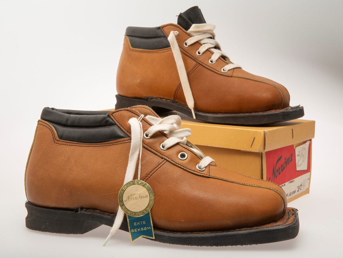 Skisko/Beksøm, lys brune med sort ankelstøtte. Sort gummisåle. Hvite skolisser. Hull til rottefellebindinger. Størrelse 41.