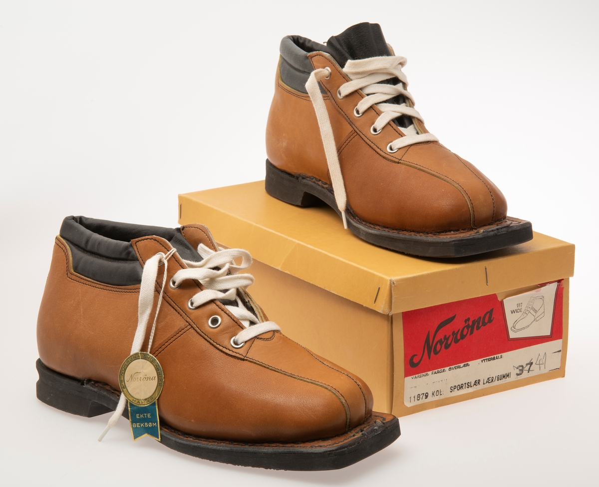 Skisko/Beksøm, lys brune med sort ankelstøtte. Sort gummisåle. Hvite skolisser. Hull til rottefellebindinger. Størrelse 41.