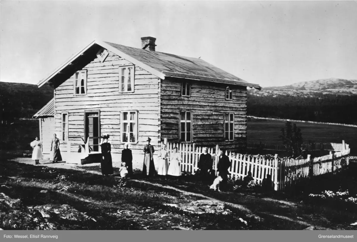 Mennesker, sannsynligvis familien Fløtten og gjester, fotografert utenfor Per Eriksen Fløttens hus i Strømsbukt, 1897.