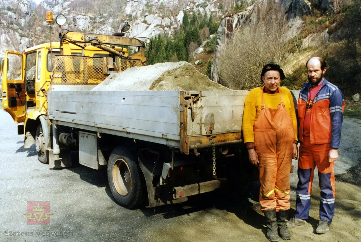 Lapping med grus. I tidligere tider en vanlig oppgave i vegvedlikeholdet. Her på 1980 tallet i Dalane. 
Trolig brukes en Volvo F6 i arbeidet. 

Se Relasjon/Relaterte objekter. 
Gjenstandsnummer NVM 00-G-02407 viser en Volvo F616 fra 1983 som ble brukt til vegmerkemaskin.