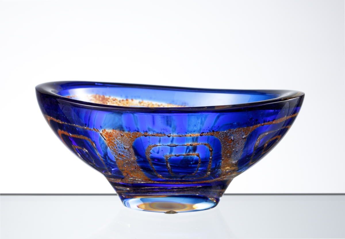 Design: Sven Palmqvist. Mindre, oval, ravenna-skål med klack nr 6338 i blått och brunt mönster. Konstnär Sven Palmqvist.