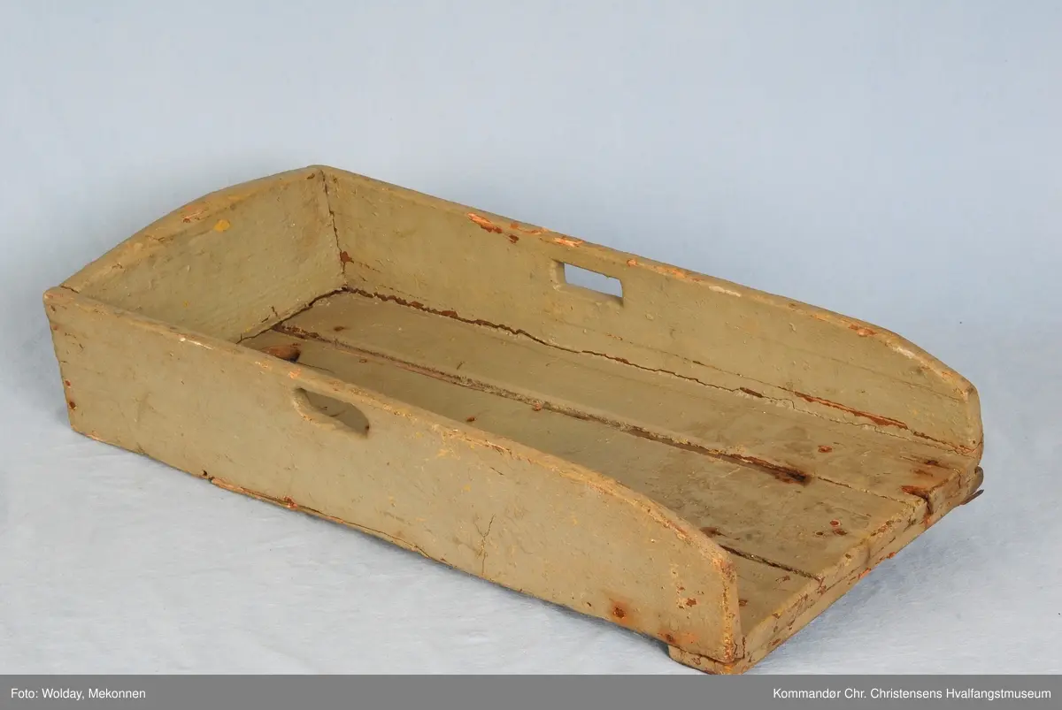 Rektangulært trau med bærehåndtak i sidene. Minkende høyde mot åpningen. Snekret kasse åpen i en ende.