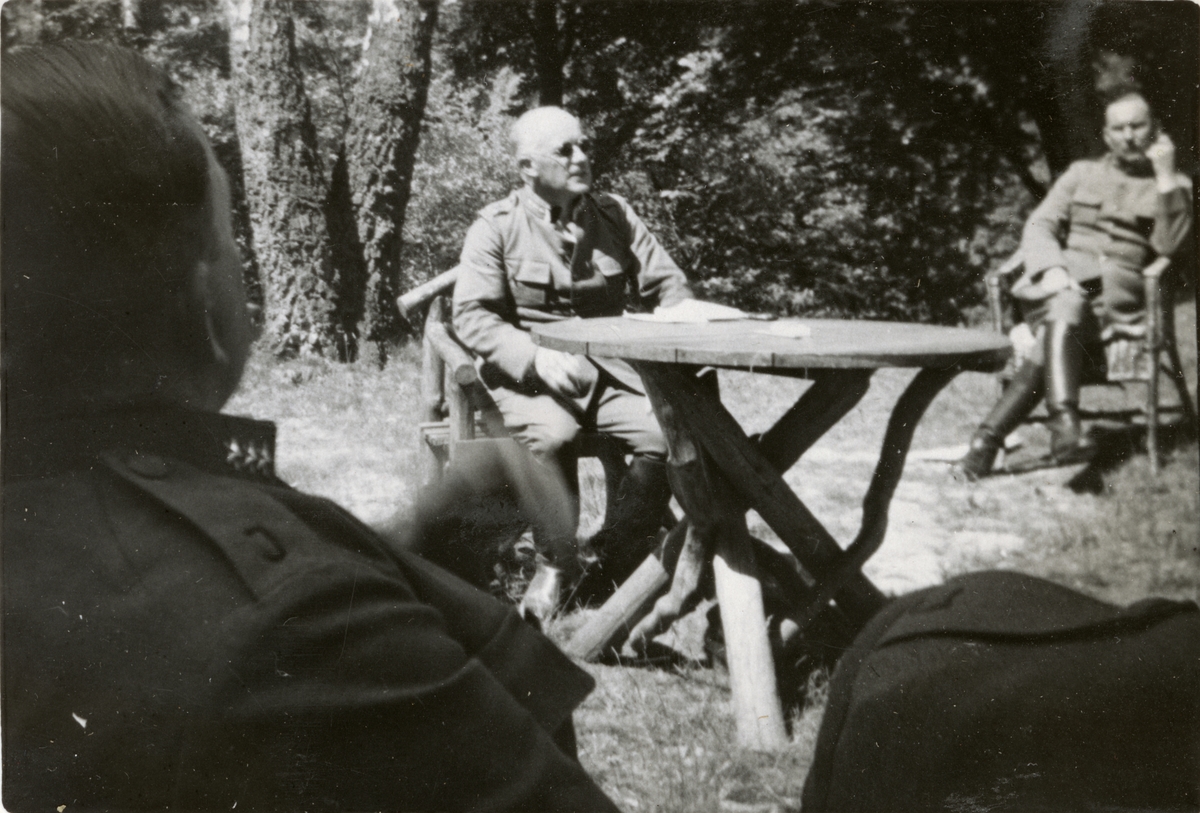 Text i fotoalbum: "1936 juni. Intendentur-fältövningen i Röstånga. Diskussion i det gröna. Arntz".