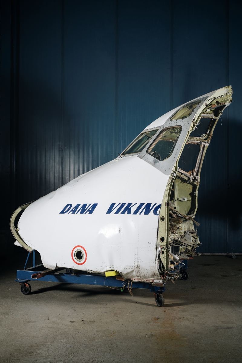 Nossektion, enstaka motordelar, två kabinstolar samt cabin dividers från jetflygplanet MD-81 Dana Viking. Nossektionen är rensad på instrument. Vitmålad nossektion med blå dekor: "DANA VIKING". Stolar metallrena med blå klädsel.