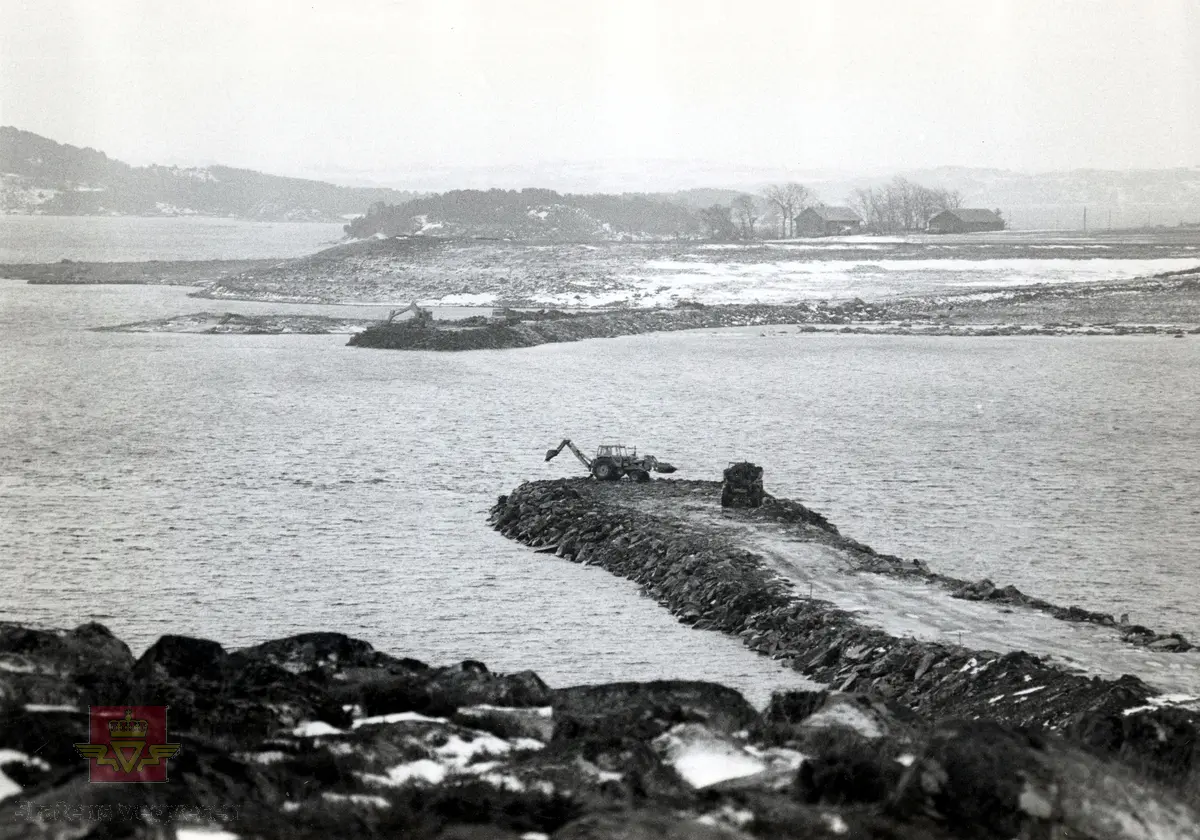 Dyrkningsstein til fylling for Askjesundbrua, Rennfast.  Dyrkningsstein fra Askje / Mosterøy ble kjørt til fylling i Askjesundet og brukt som vegfylling og brufundament for Askjesundbrua, Europaveg 39. Bønder leverte dyrkningsstein til fyllingen og fikk betalt for leveringen. Gravemaskin og dumper på fylling.