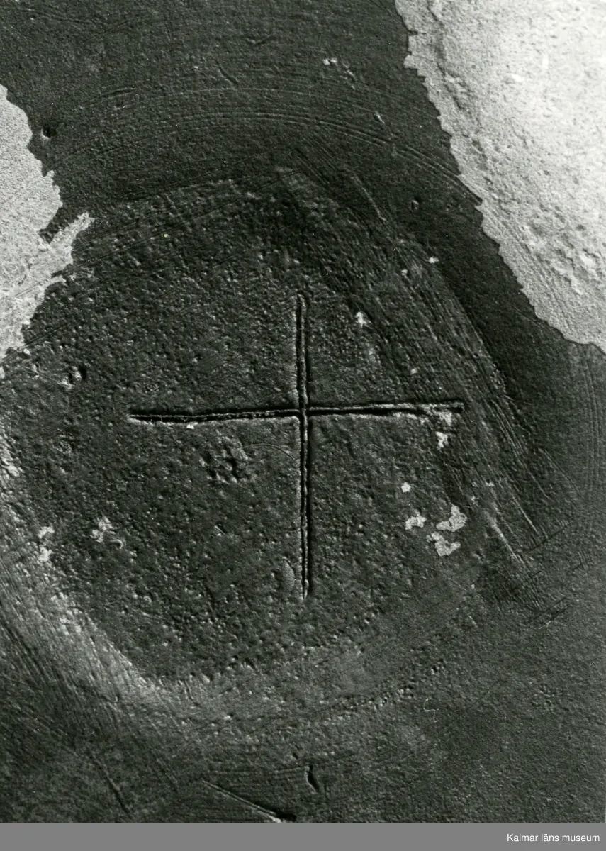 KLM 46428 Kanna av tenn. Bukig form. Hankkärl, försedd med lock och handtag, vidgad botten neråt. I botten, invändigt en medalj med korsfästelsebild. Medaljens kant försedd med pärlring. Ägarmärke/bomärke på lockets och bottens utsidor. Handtaget ornerat med drakmotiv och bladslinga, tumgreppet saknar ett av ekollonen. Kannan skadades svårt vid upphittandet, genomgående sprickor på många ställen.