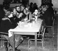 Samling med regementets personal 1979-12-18.

Efter medalj- och prisutdelning följde kaffedrickning. Frv ass Kerstin Fältskog, fdfm Karl-Erik Olsson och Sören Olsson, fj Kjell Hansson, fm Valborg Karlsson och på höger sida övlt Anders Starck.