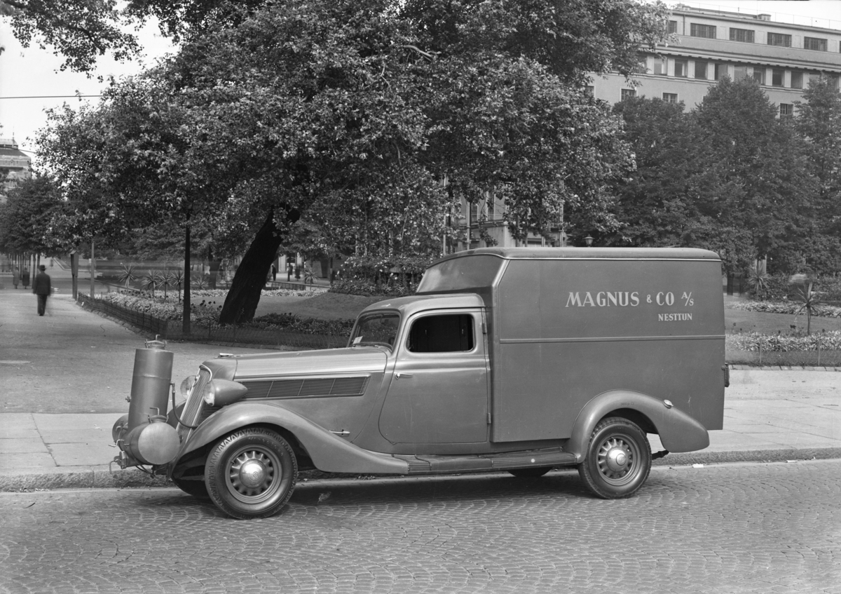 Varebil fra Magnus & Co a/s. Musikkpaviljongen i bakgrunnen.