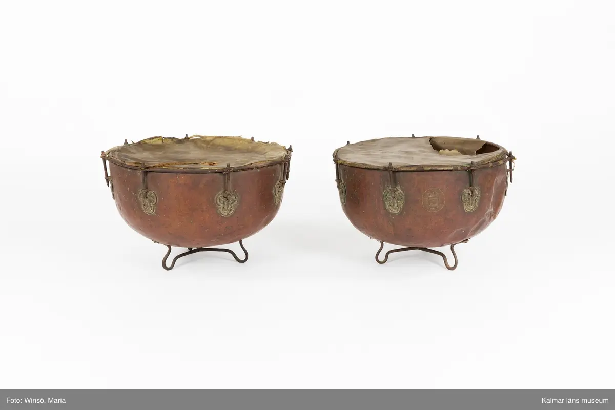 KLM 14939. Puka. Av koppar med beslag av järn och skinn på ovansidan. Står på tre korta ben formade som öglor. På utsidan skruvar och beslag formade som tulpaner. Försedd med Stålhammarska vapnet. Par med KLM 14940. Har eventuellt använts tillsammans med pukstockar KLM 14850-51.