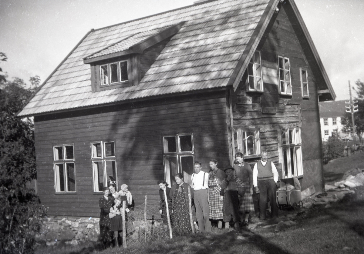 Gruppeportrett av en familie foran et bolighus i Spjelkavik?