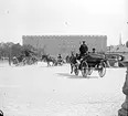 Stockholms slott med hästdroskor och en bil.