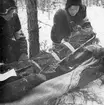 Första hjälpen utförs på soldat som agerar skadad vid sjukvårdsövning i fält vid F 11 Södermanlands flygflottilj, 1945. Stabilisering av ben vid lårbensbrott.

Vintertid.

Ur fotoalbum 