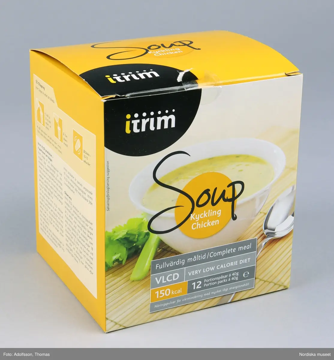 Fyrkantig kartong med viklock för 12 portionspåsar näringspulver av typen "Soup Kyckling". Gul dekor samt bild på produkten i konsumtionsfärdigt skick på framsidan. Exempel på text: "Fullvärdig måltid /Complete meal VLCD Very Low Calorie Diet 150 kcal Näringspulver för viktminsking med mycket lågt energiinnehåll". Övriga sidor har riklig information om produktens ingredienser och rekommendationer för användningen. Se länkade filer.