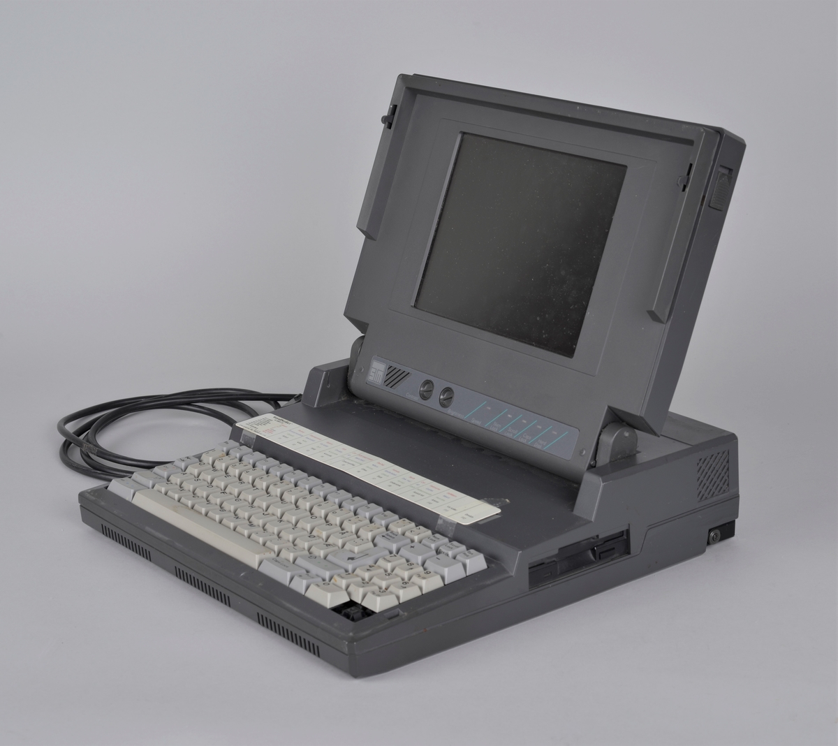 Personlig datamaskin, eldre type
Bærbar med skjerm og tastatur. 

http://www.pccm.be/museum/pc%20museum%20STM%205500.html

Specs:
Name: STM 5500
Manufacturer: Honeywell
Type: Portable Computer
Year: ?
CPU: Intel 80286
Speed: 12 MHz
RAM: 4 MB
Graphics: ? EGA I think....
Colours: Monochrome (Red gas plasma display)
I/O: RS232c, Centronics, Monitor
Built In Media: 1 3.5" HD FDD, 1 40 MB SCSI HDD
OS: DOS 6.22, Windows 3.0