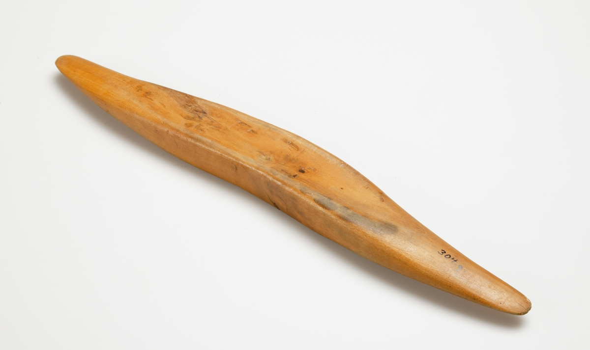 Vävskyttel av trä (8 st).
Vågformad kontur. Avlångt hål med små benplattor omkring hålen för stången. 
a) med svart tråd
f) med tom tråd "tuta". 1894 skrivet med bläck.
Resterande skyttlar är tomma.

Mått:
Längd: 280 mm
Längd hål: 90-105 mm
Bredd: 35-45 mm