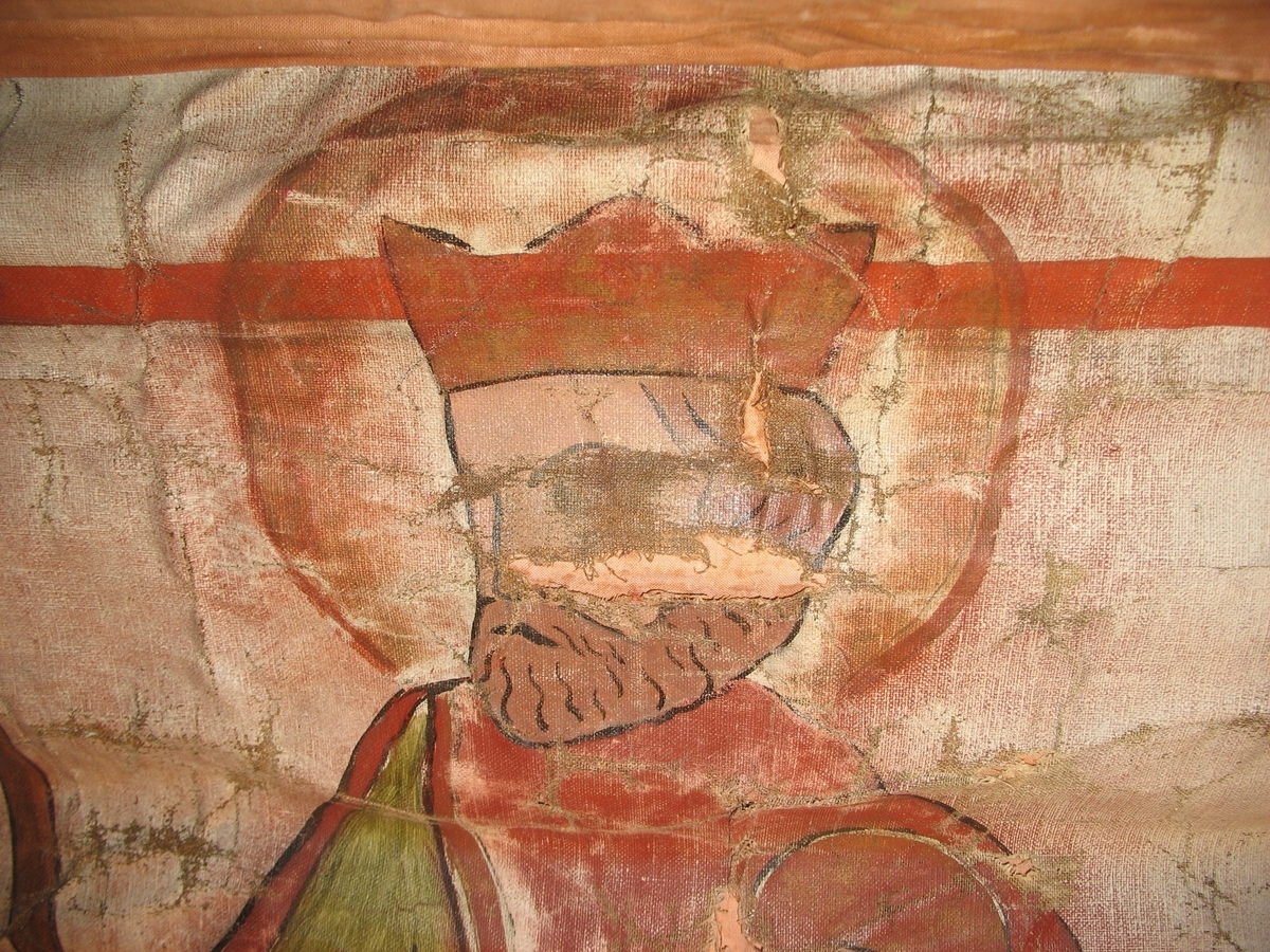 Øvre del: Olav Haraldsson med krone, kappe og øks, som står på en "underligger" formet som en drage med menneskeansikt. Nedre del: påsydde blomster