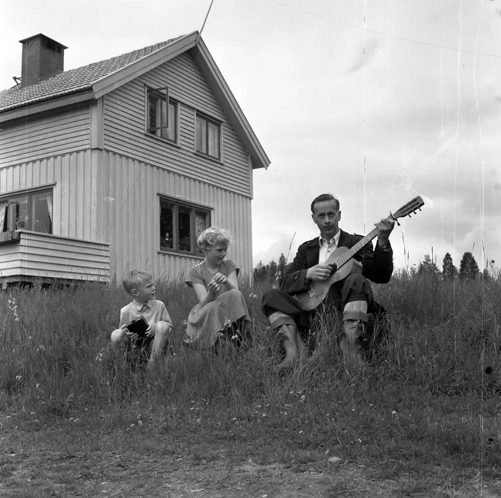 Fotografi av Vidar Sanbeck og to barn utenfor et hus.