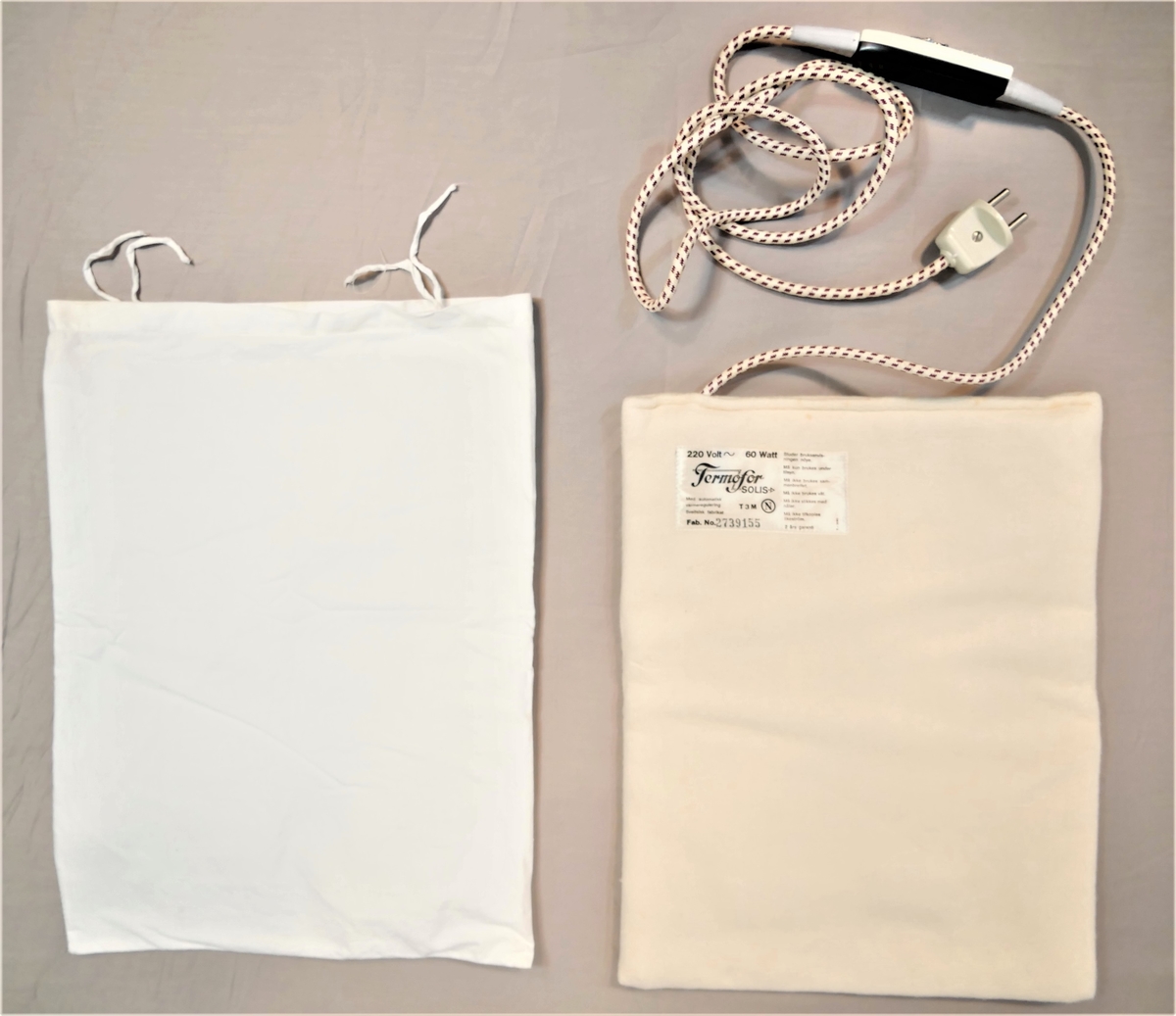 Flat pute med innsydd elektrisk kabel, ledning med brytar og støpsel.
Lerretstrekk utanpå.