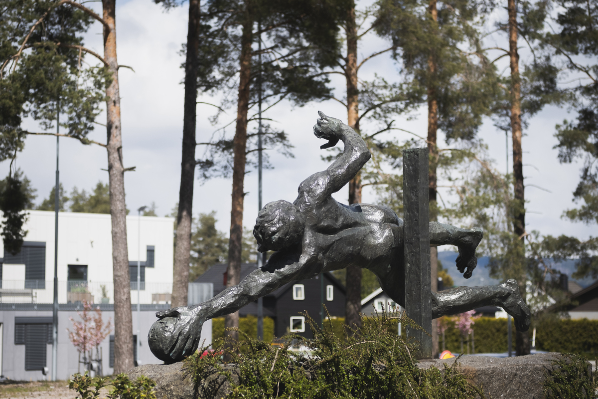 Mannfigur som slenger seg etter ball.