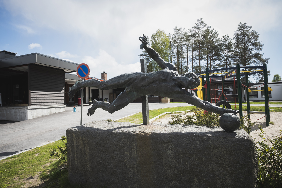 Mannfigur som slenger seg etter ball.