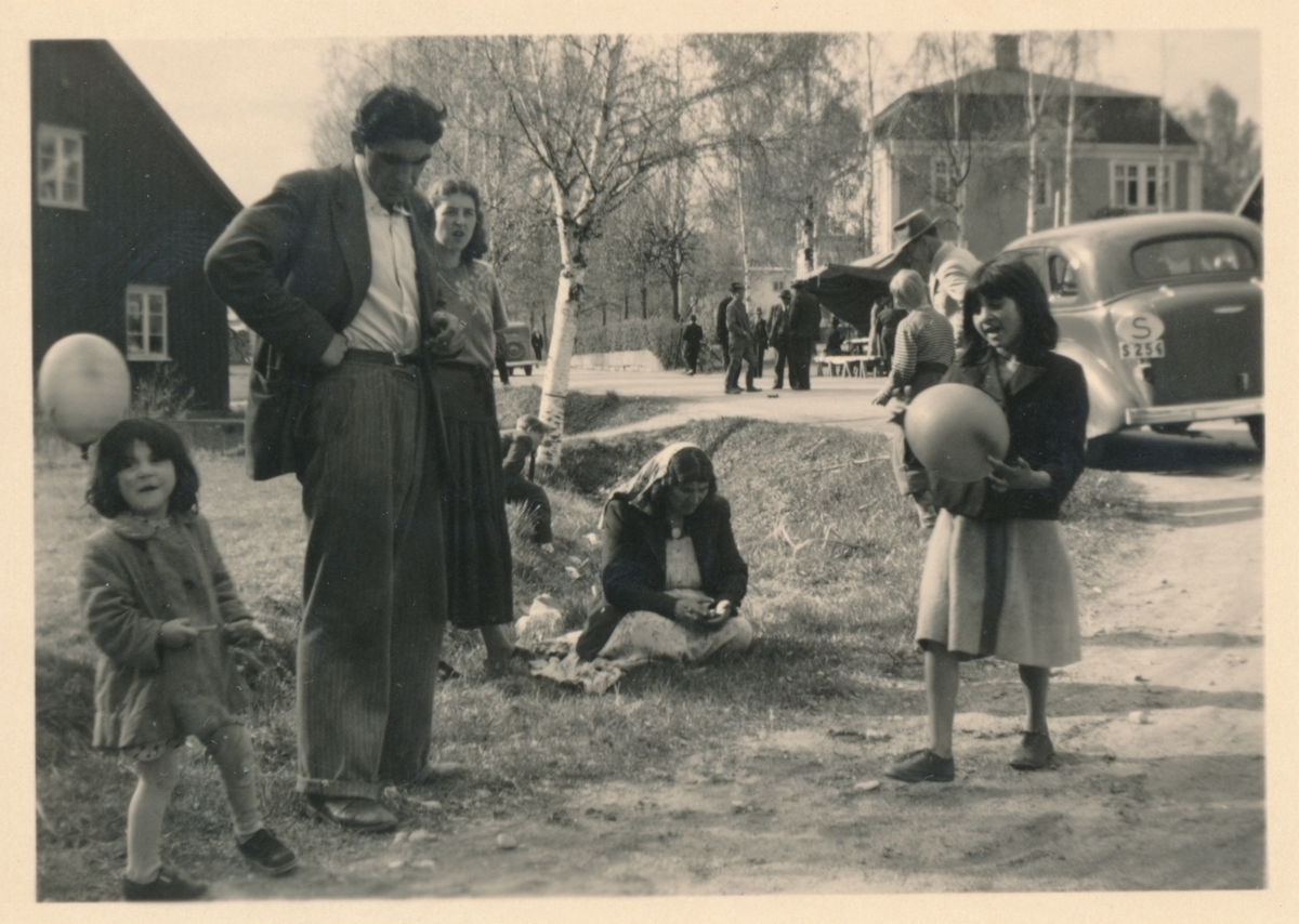 Vid en vägkant har en familj samlats, troligen i samband med Torsby marknad 1949.