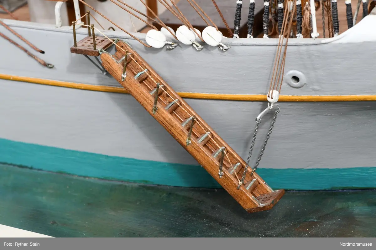 Tre mastet fullrigger, rigg uten seil, på sokkel.
Skroget montert på en kraftig sokkel av sponplate og tre. Overside malt som sjø. Hamptau langs kanten.