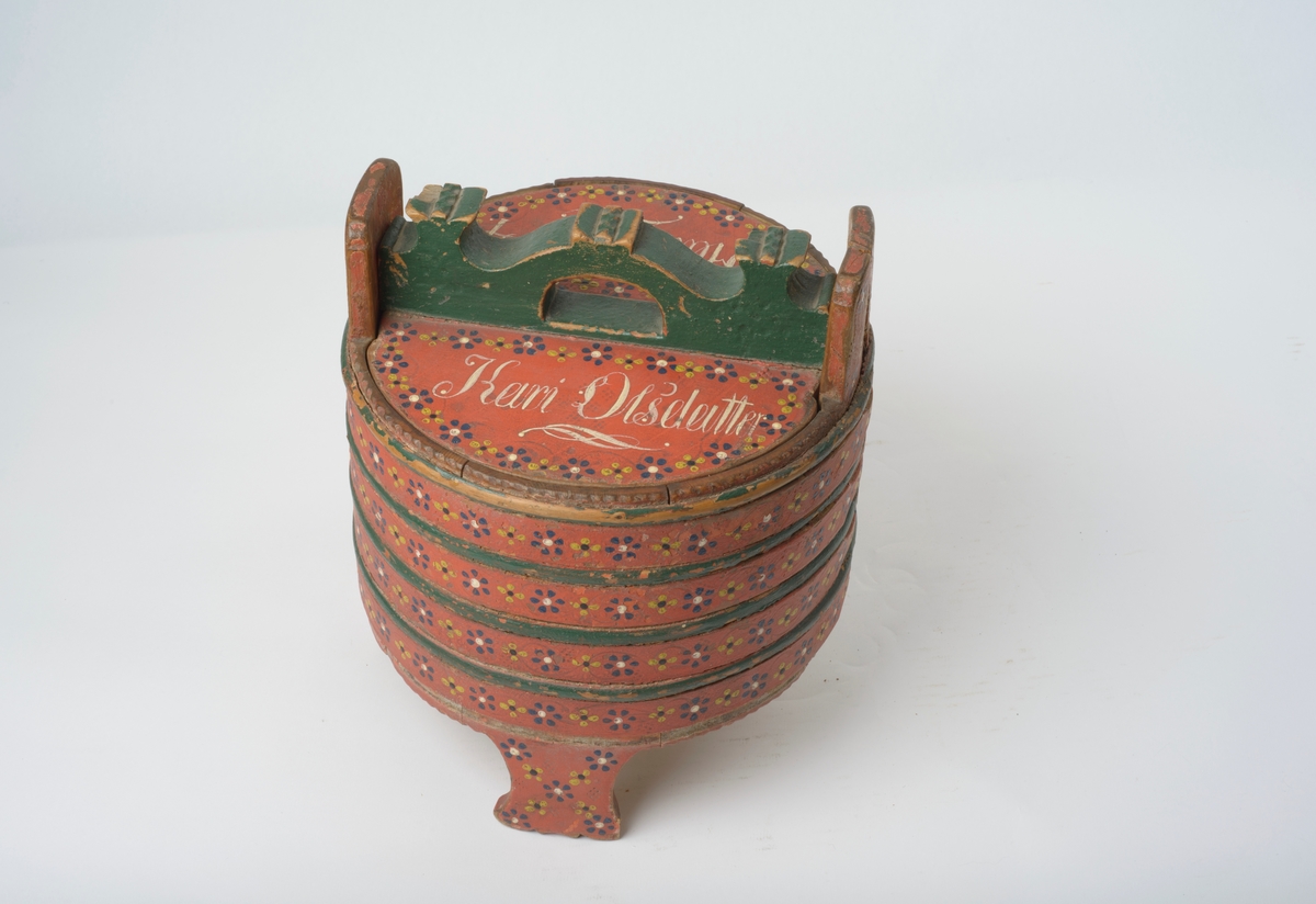 11 staver, tildels sterkt avrundet, holdt sammen med fire flate og fem avrundete gjørler. Tre staver forlenget til bein, dobbelt dyrefot, to staver forlenget til ører, gjennomhullet sirkulære hull. Botn felt inn i stavene, spår for lokket i stavene. Lokk, sirkulært hakk for øra. Felt inn handtak, buet, med tre kroner, halvsirkel hull for hand.