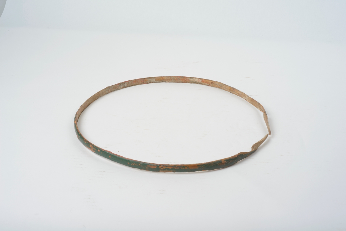 11 staver, tildels sterkt avrundet, holdt sammen med fire flate og fem avrundete gjørler. Tre staver forlenget til bein, dobbelt dyrefot, to staver forlenget til ører, gjennomhullet sirkulære hull. Botn felt inn i stavene, spår for lokket i stavene. Lokk, sirkulært hakk for øra. Felt inn handtak, buet, med tre kroner, halvsirkel hull for hand.