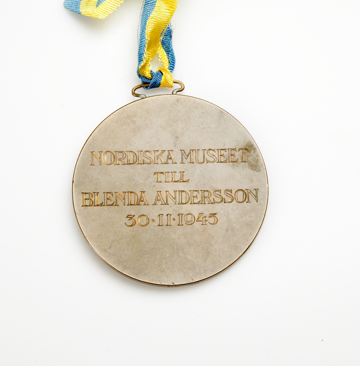 Inglasat diplom inom förgylld ram och medalj. 
"Fröken Blenda Andersson, Skörda, Vislanda. Härmed har jag äran meddela, att Nordiska museets nämnd på museets högtidsdag denna dag tilldelat Eder sin Artur Hazelius-medalj i brons såsom ett erkännande av Edra insatser till Nordiska museets och den svenska folklivsforskningens fromma. Medaljen översändes samtidigt härmed. Stockholm den 30 november 1945".

Rund medalj i brons med profilbild av Artur Hazelius i relief på ena sidan, text "Nordiska museet till Blenda Andersson 30-11-1945" på andra sidan. Hänger i blågult sidenband.