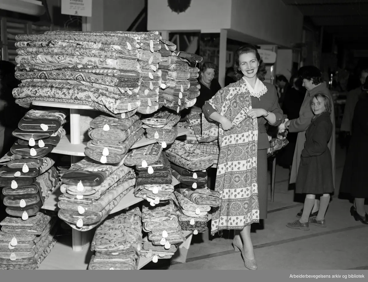 Gerd Østreng prøver kjolestoffer i en manufakturforretning i Oslo. April 1953.