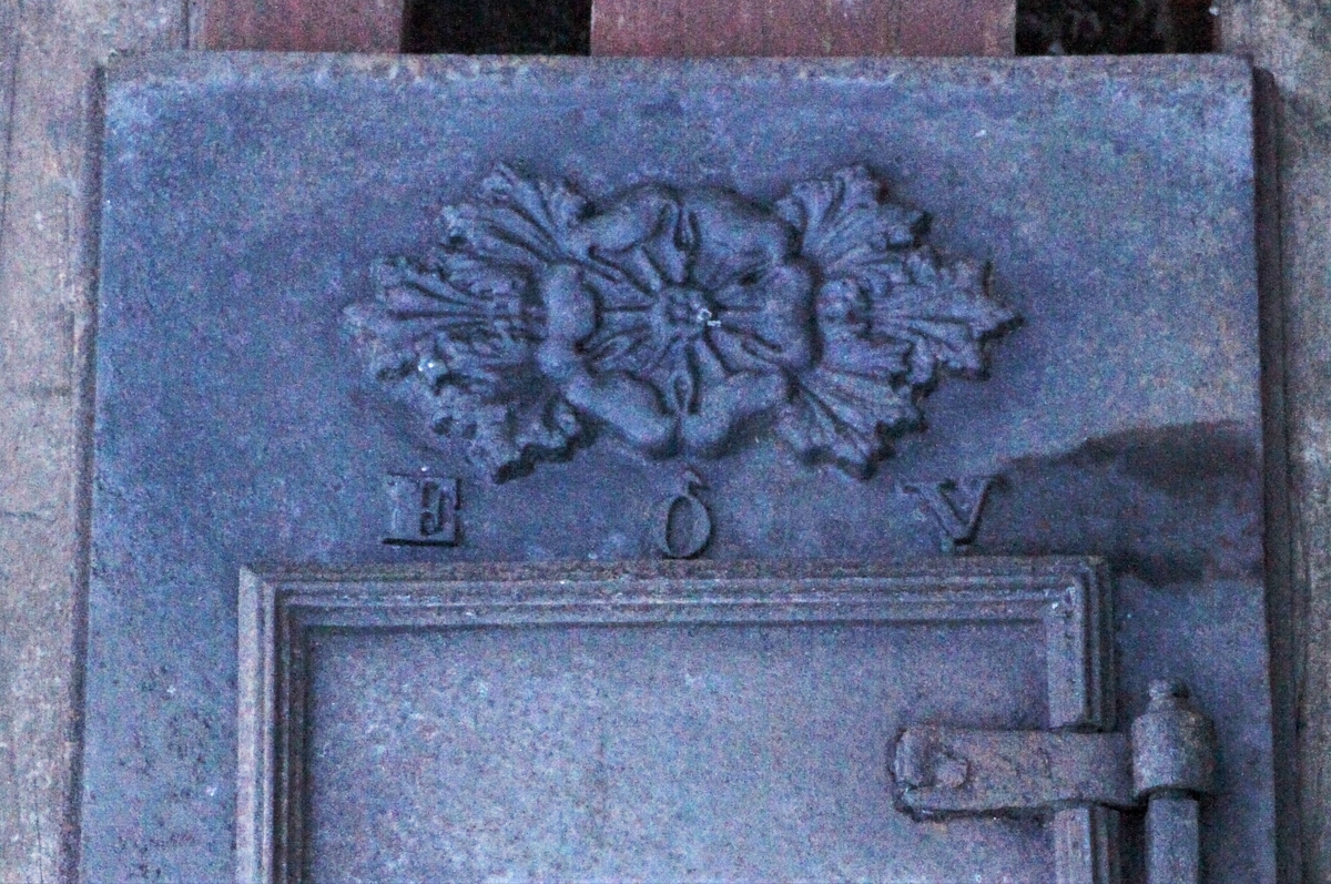 Ovnen er i fire etasjer, over ovnsdøra er merket E ♂ V som trolig står for Eidsfos Jernverk. Ovnsporten har gjennombrudt mønster av blomster og border, avrundede og riflede hjørner. På toppen en gesims som går noe utover. Ovnen står på fire støpte bein hvis nederste del ender i en volutt. Ovnen sto i sin tid i storstua på Hallingstad der kommunestyremøtene i Østre Toten ble holdt i en rekke år. Seinere ble den flyttet til Løken i Vestre Toten.